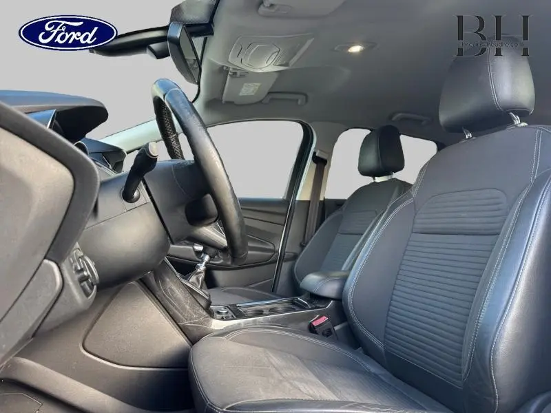 Intérieur avant droit du Ford Kuga 2017 avec sièges sport en cuir noir et volant multifonction en cuir.