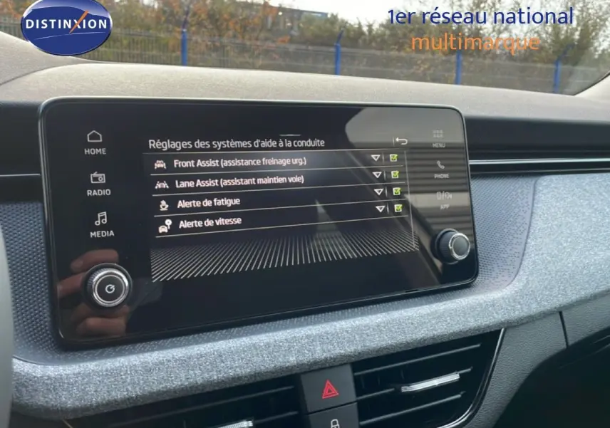 Écran tactile central affichant les réglages d'aide à la conduite dans l'habitacle gris noir du Skoda Kamiq 2025.