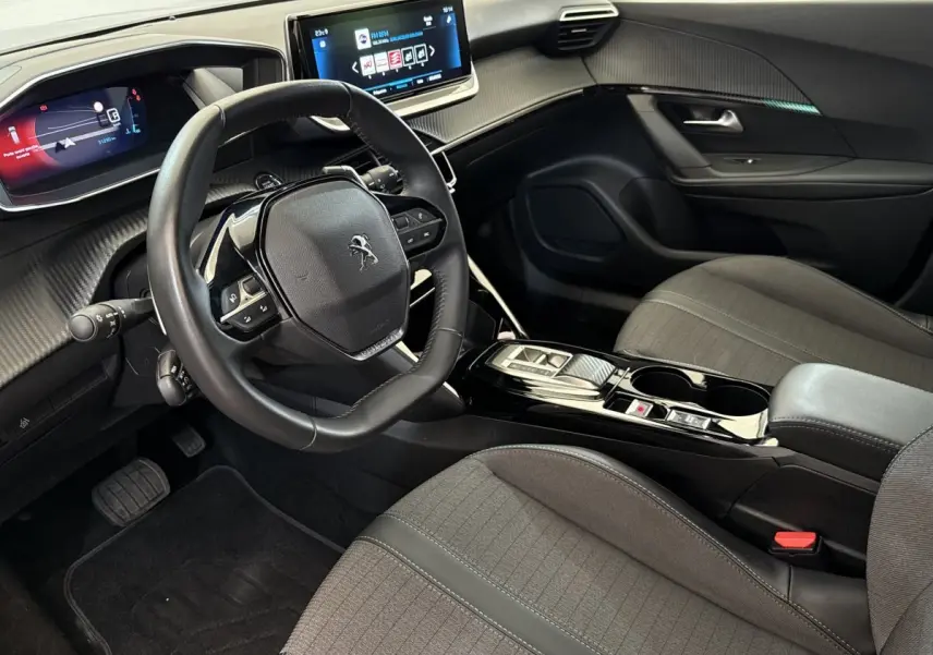 Intérieur de la Peugeot 2008 PureTech 130 gris clair, vue côté conducteur avec tableau de bord digital et écran tactile central.