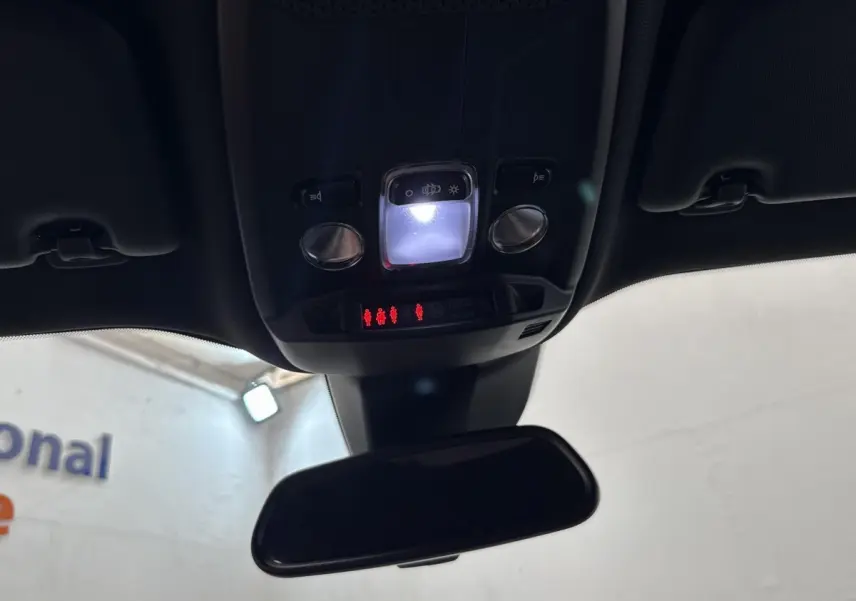 Vue intérieure en plongée sur le plafonnier et le rétroviseur d'une Peugeot 2008 gris clair, avec éclairage LED allumé.