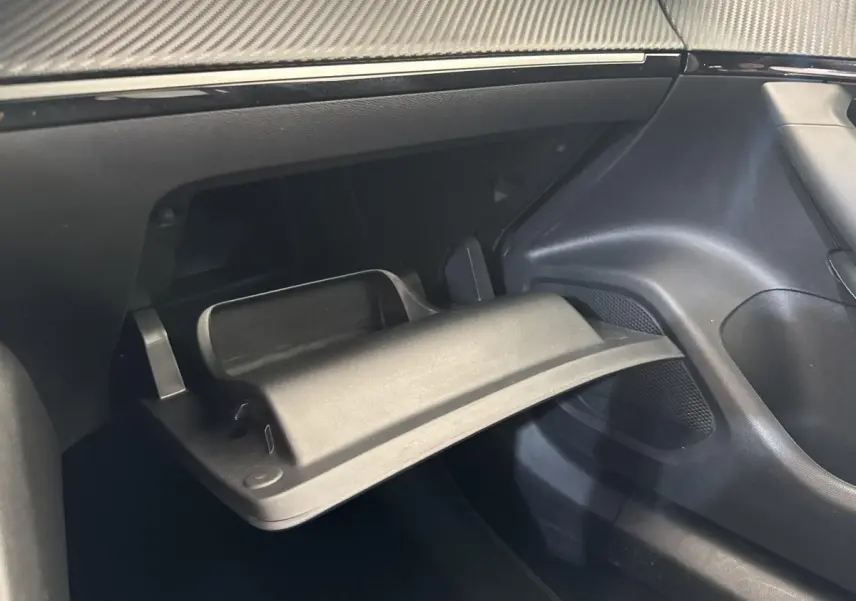 Gros plan sur la boîte à gants ouverte côté passager du Peugeot 2008 gris clair, intérieur noir moderne.