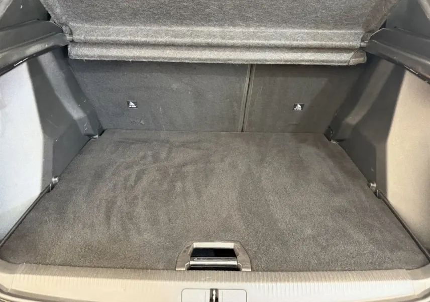 Coffre ouvert vu de l'arrière d'un Peugeot 2008 gris clair, montrant un espace de chargement propre et plat.