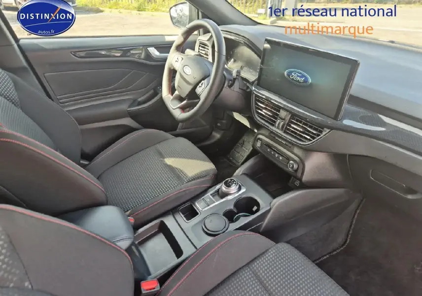 Intérieur avant droit de la Ford Focus 2024 gris magnétique, volant cuir sport et écran tactile central visible.
