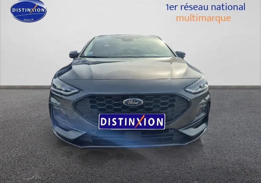 Vue frontale d'une Ford Focus gris magnétique avec calandre hexagonale et phares LED fins.