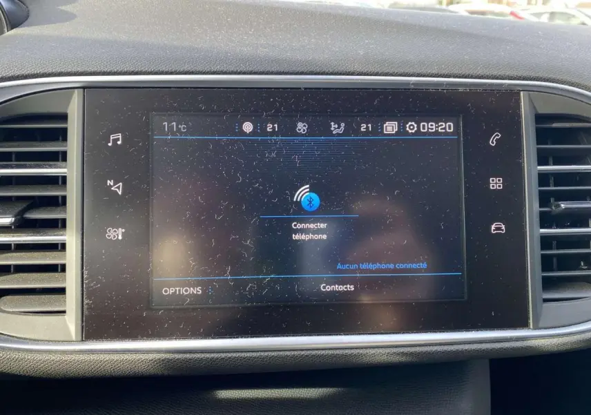 Écran tactile central de la Peugeot 308 blanc nacré 2017 affichant la connexion Bluetooth au téléphone.