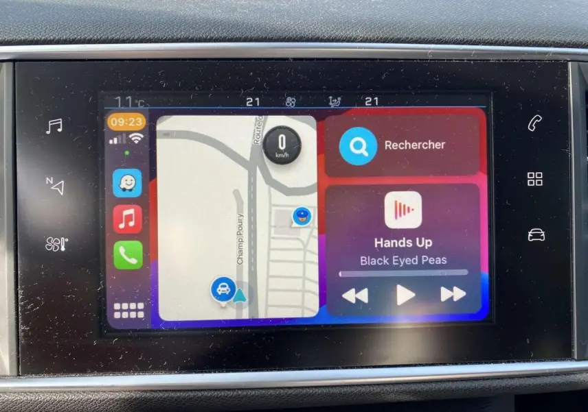 Écran tactile 9,7'' de la Peugeot 308 blanc nacré affichant navigation et musique en intérieur véhicule.