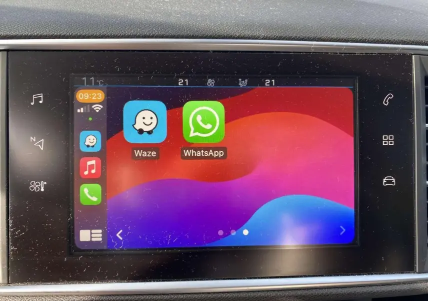 Écran tactile 9,7'' de la Peugeot 308 blanc nacré montrant les applications Waze et WhatsApp en interface connectée.