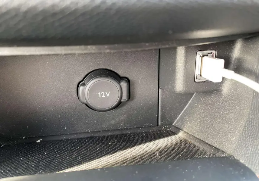 Prise 12V et port USB avec câble blanc dans l’habitacle noir de la Peugeot 308 blanche, version Allure.