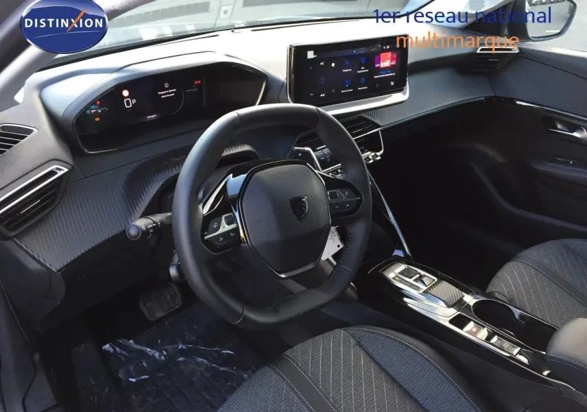Intérieur moderne de la Peugeot 208 hybride 2025, vue côté conducteur sur le tableau de bord et volant noir.