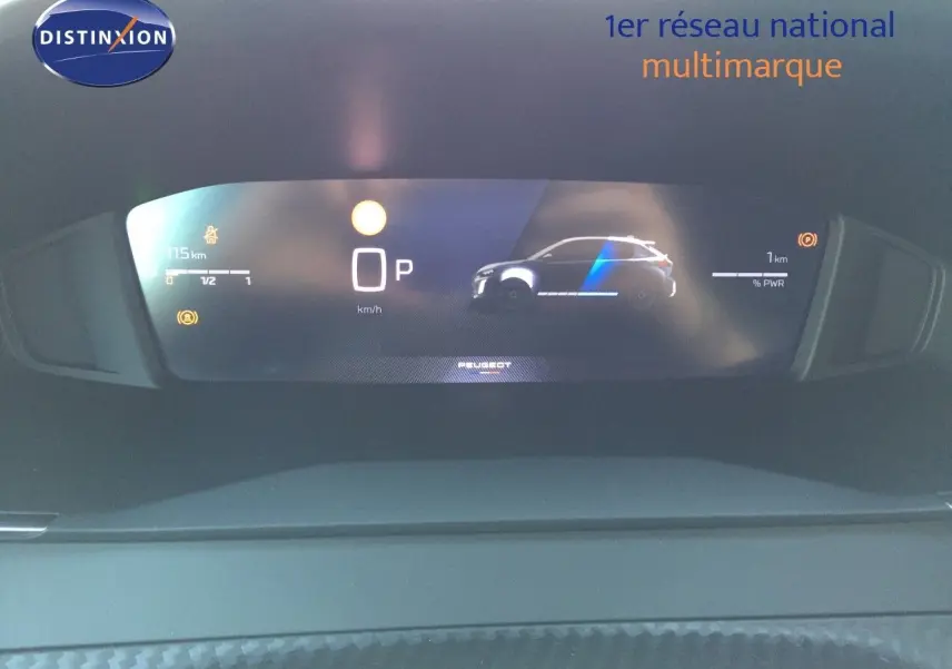 Tableau de bord numérique de Peugeot 208 hybride 2025 affichant la vitesse à l'arrêt et l'autonomie restante.