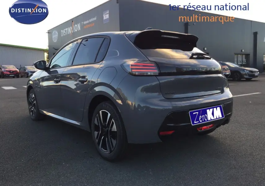 Vue 3/4 arrière droite d'une Peugeot 208 hybride gris sélénium métal avec feux arrière LED et jantes noires.