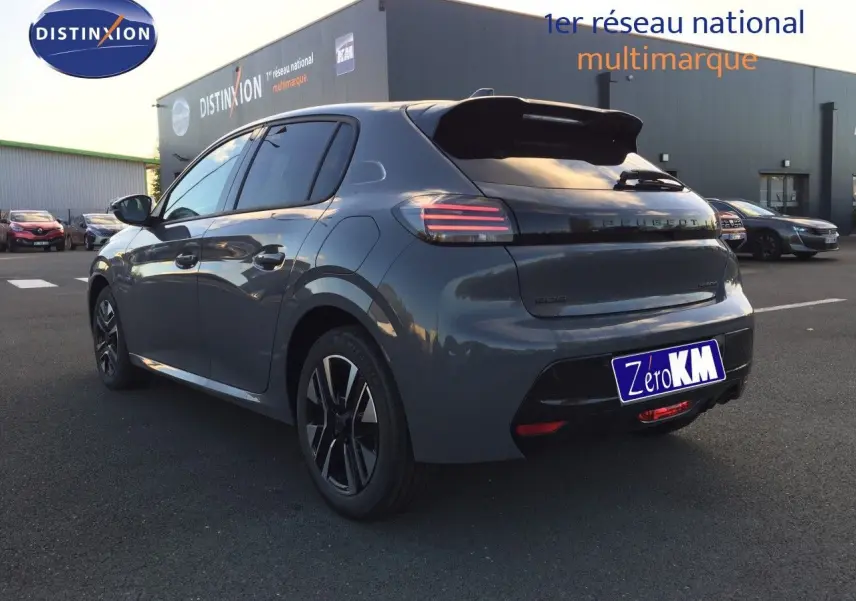 Vue 3/4 arrière gauche d'une Peugeot 208 hybride 2025 gris selenium metal avec feux arrière LED et jantes alliage.