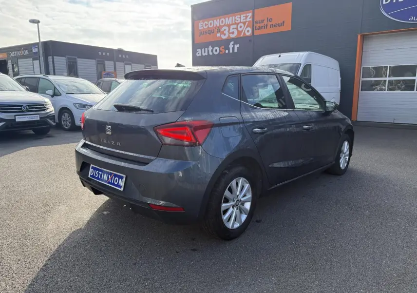SEAT Ibiza 1.0 EcoTSI 95 Xcellence gris Magnetic Tech vue 3/4 arrière droit sur parking extérieur.