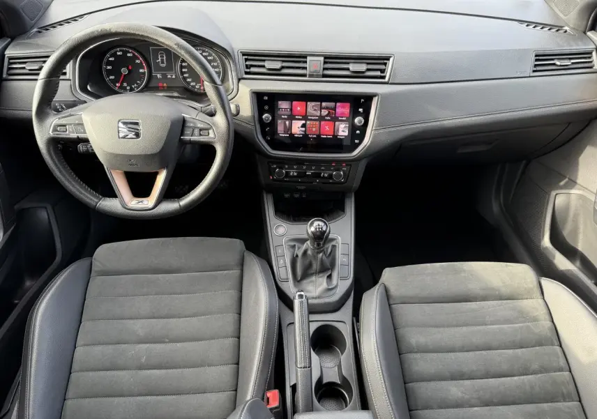Intérieur de la SEAT Ibiza 2019 vu de face, tableau de bord noir avec écran tactile et boîte manuelle.