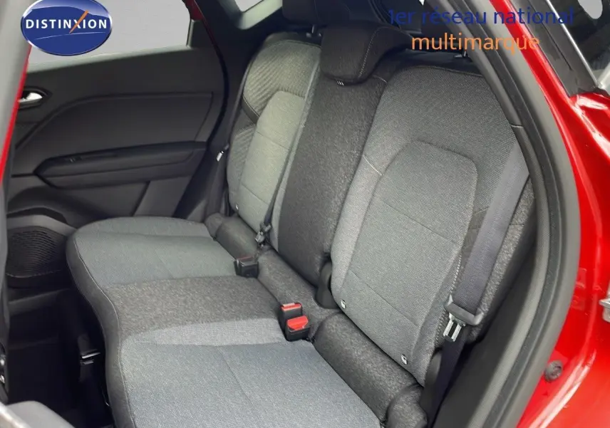 Vue intérieure arrière côté gauche du Renault Captur E-Tech hybride rouge passion, montrant les sièges tissu gris et noir.