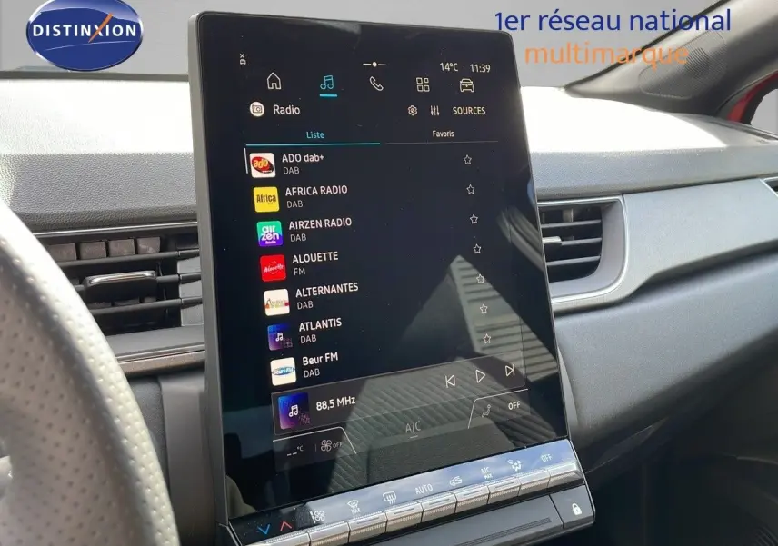 Écran tactile vertical du système multimédia dans l'habitacle du Renault Captur rouge passion toit noir, vue côté conducteur.