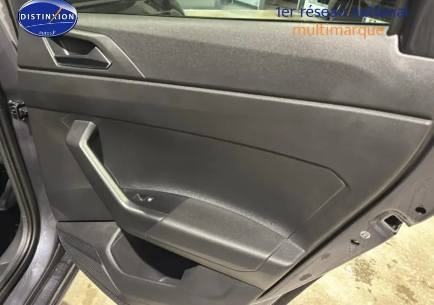 Vue rapprochée de la porte arrière gauche gris cendre de la Volkswagen Polo 2025 avec poignée intégrée et commande de vitre.
