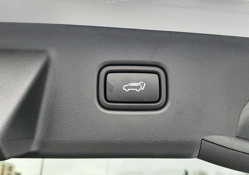 Bouton d'ouverture électrique du hayon sur la partie intérieure du coffre d'un Hyundai Tucson gris Shimmering Silver.