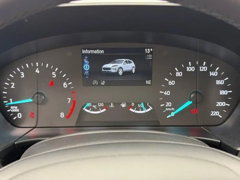 Vue du tableau de bord du Ford Kuga 2024, affichage numérique central montrant un Kuga blanc en 3/4 avant.