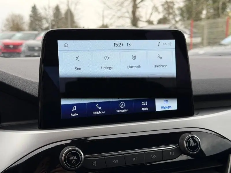 Écran tactile central du tableau de bord du Ford Kuga 2024, affichant les réglages audio et téléphone en intérieur.