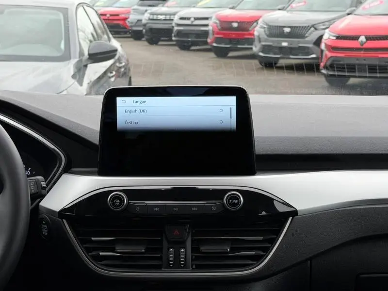 Vue intérieure du tableau de bord du Ford Kuga 2024 avec écran tactile central et commandes audio, volant à gauche visible partiellement.