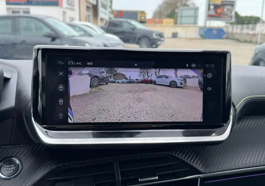 Écran tactile intérieur de la Peugeot 208 Hybrid 110 e-DCS6 GT montrant la caméra de recul, avec tableau de bord noir et détails carbone.
