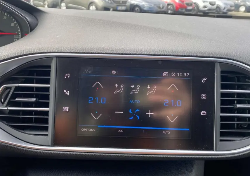 Écran tactile central de la Peugeot 308 2018 affichant la climatisation automatique bi-zone à 21°C.