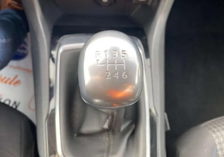 Gros plan sur le levier de vitesses manuel argenté de la Peugeot 308, entouré de sellerie noire et console centrale.