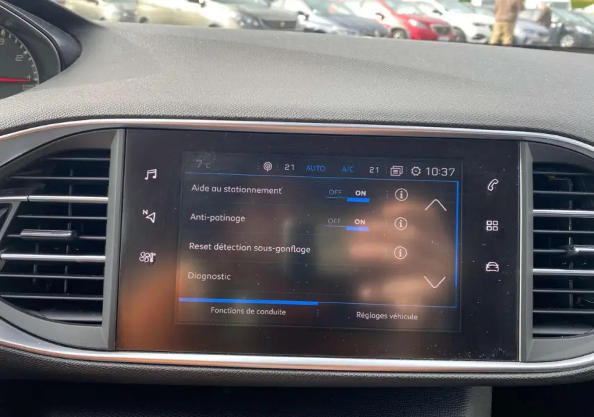 Écran tactile central de la Peugeot 308 2018 affichant les aides au stationnement et réglages de conduite.