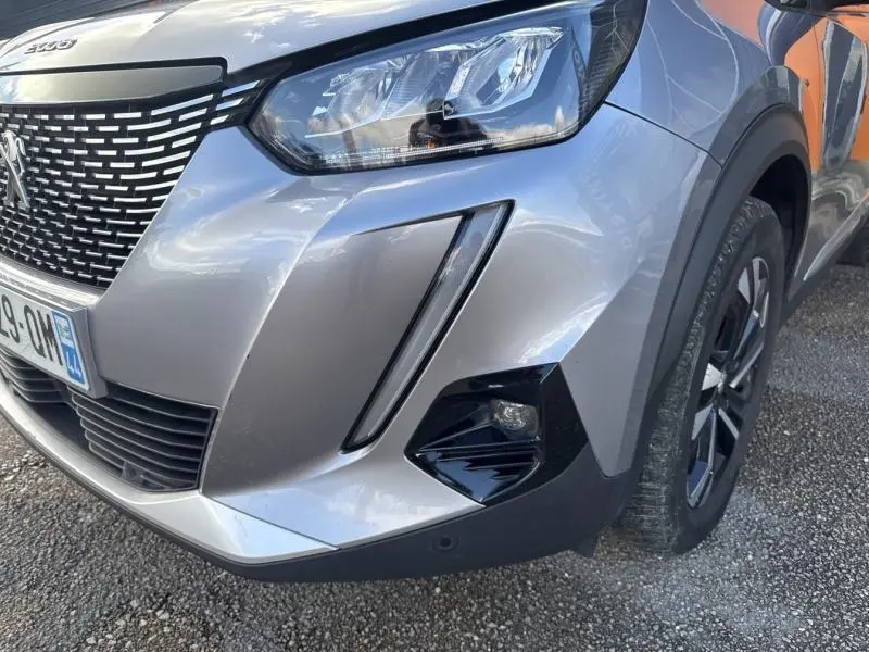 Gros plan sur l'avant droit gris Artense du Peugeot 2008 2020, mettant en valeur le phare LED et la calandre noire texturée.