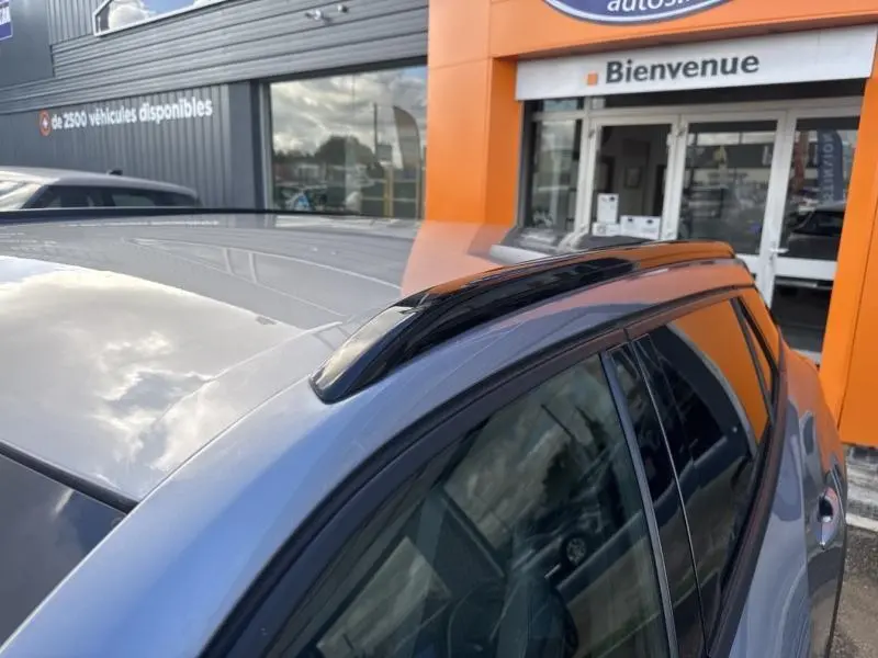 Vue rapprochée du toit et des barres de toit noir brillant d’un Peugeot 2008 gris Artense, côté droit arrière.