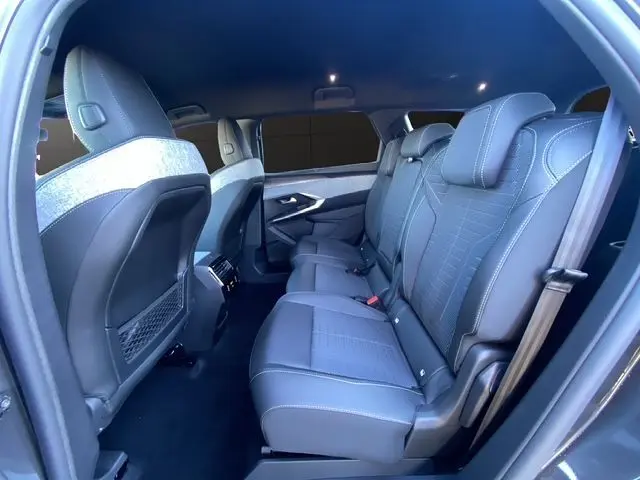 Vue intérieure côté droit des sièges arrière gris noir du Peugeot 5008 Hybrid 145 GT 2025 avec finitions modernes et tissu contrasté.