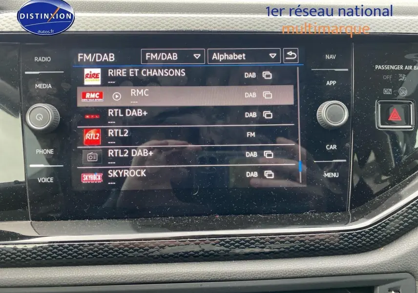 Écran tactile central de la Volkswagen Polo 2025 affichant les stations radio FM/DAB, avec finition intérieure noire et détails chromés.