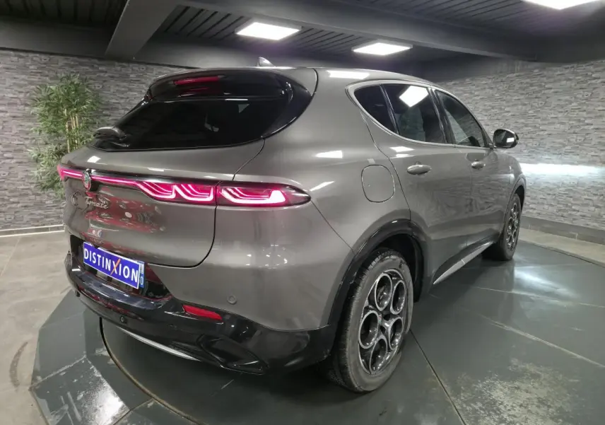 Vue 3/4 arrière droite d'une Alfa Romeo Tonale gris métallisé avec feux arrière LED et jantes alliage 18 pouces.