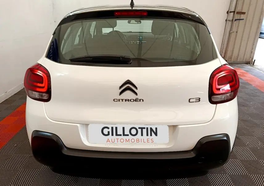 Vue arrière d'une Citroën C3 blanche 2021 avec feux arrière LED et logo centré sur un sol à damier noir et rouge.