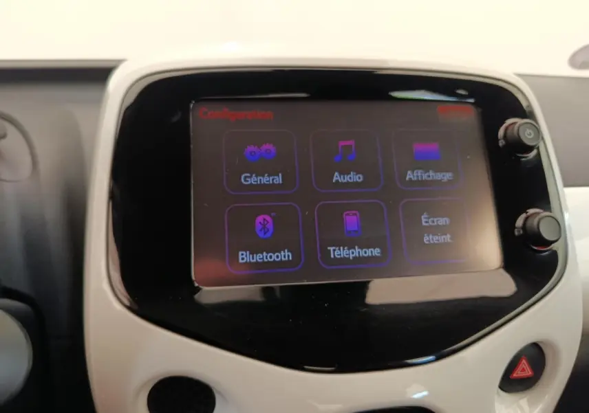 Écran tactile central de la Toyota Aygo 2016 blanc, affichant le menu Bluetooth et audio en intérieur.