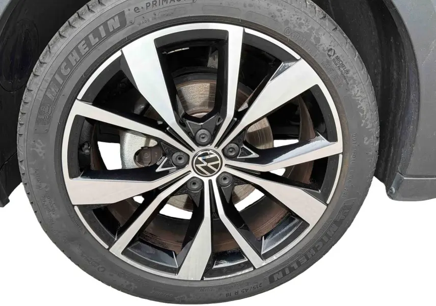 Gros plan sur la jante alliage 18 pouces bicolore noir et argent du Volkswagen T-Cross gris, avec pneu Michelin visible.