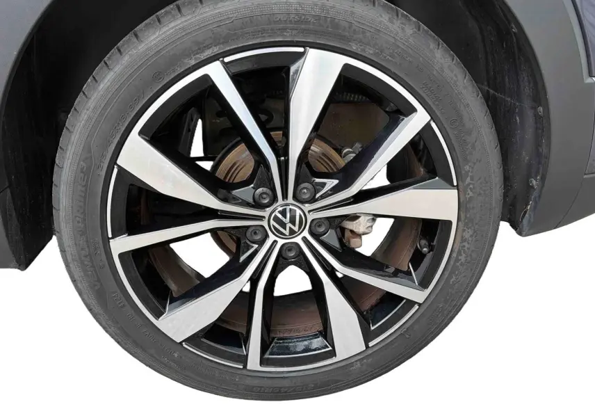 Gros plan sur la jante alliage 18 pouces bicolore noire et argentée du Volkswagen T-Cross gris, côté droit.