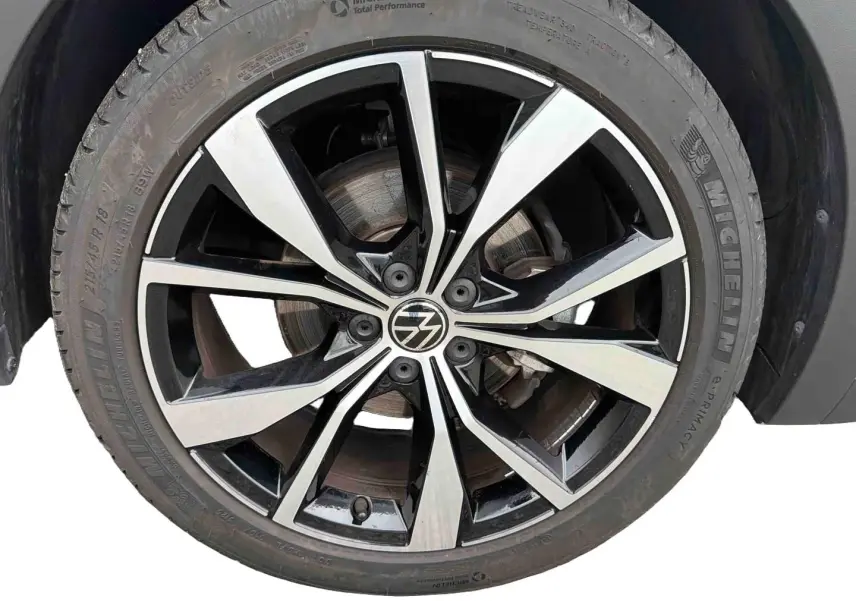Gros plan sur la jante alliage 18 pouces bicolore noir et argent du Volkswagen T-Cross gris, pneu Michelin visible.