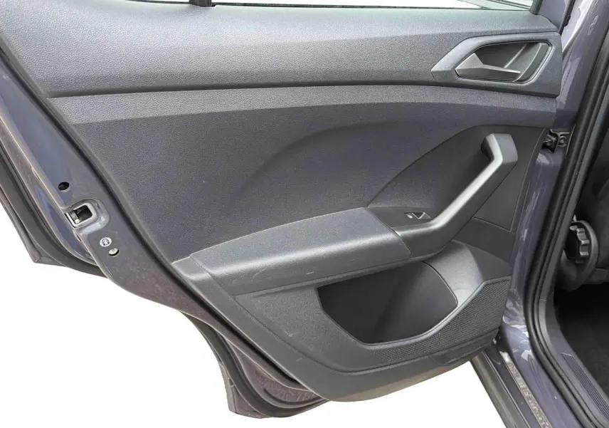 Gros plan sur la porte arrière gauche grise du Volkswagen T-Cross 2025, montrant la poignée et le panneau intérieur.