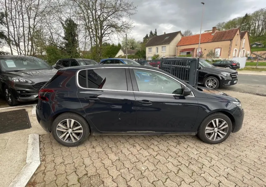 Peugeot 308 gris hurricane vue de profil côté gauche, avec vitres surteintées et jantes alliage.
