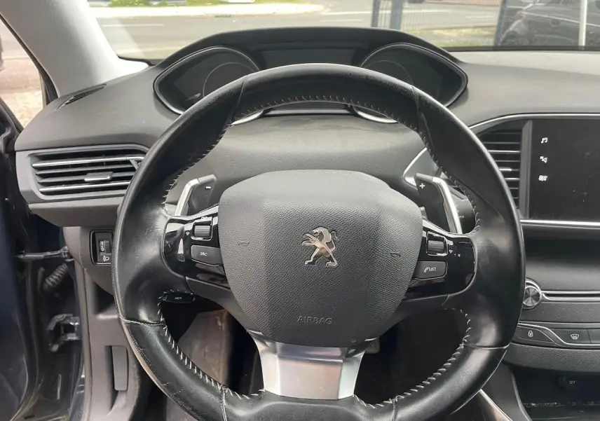 Volant en cuir noir de Peugeot 308 2018, vue frontale de l'habitacle avec tableau de bord et écran tactile visible.