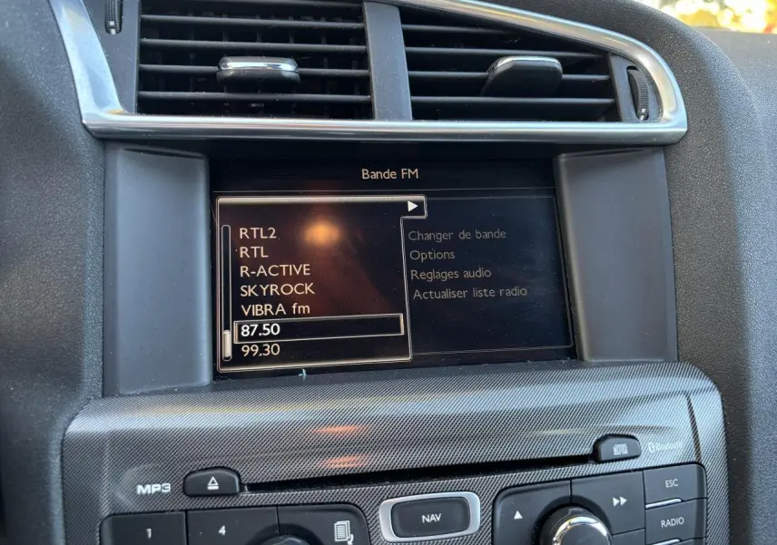 Gros plan sur l'écran de navigation eMyWay et la console centrale de la Citroën C4 gris clair de 2012.