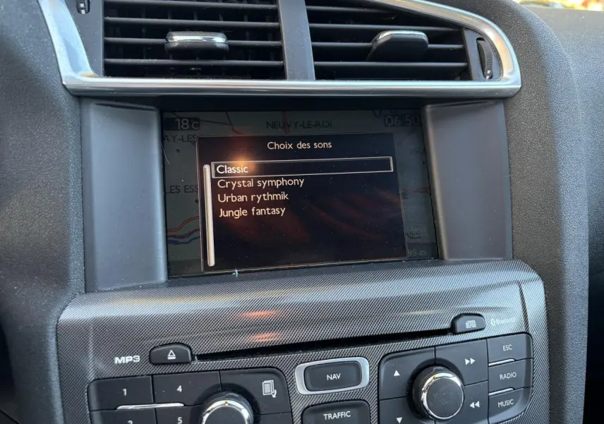 Gros plan sur l'écran de navigation eMyWay et la console centrale carbone d'une Citroën C4 gris clair de 2012.