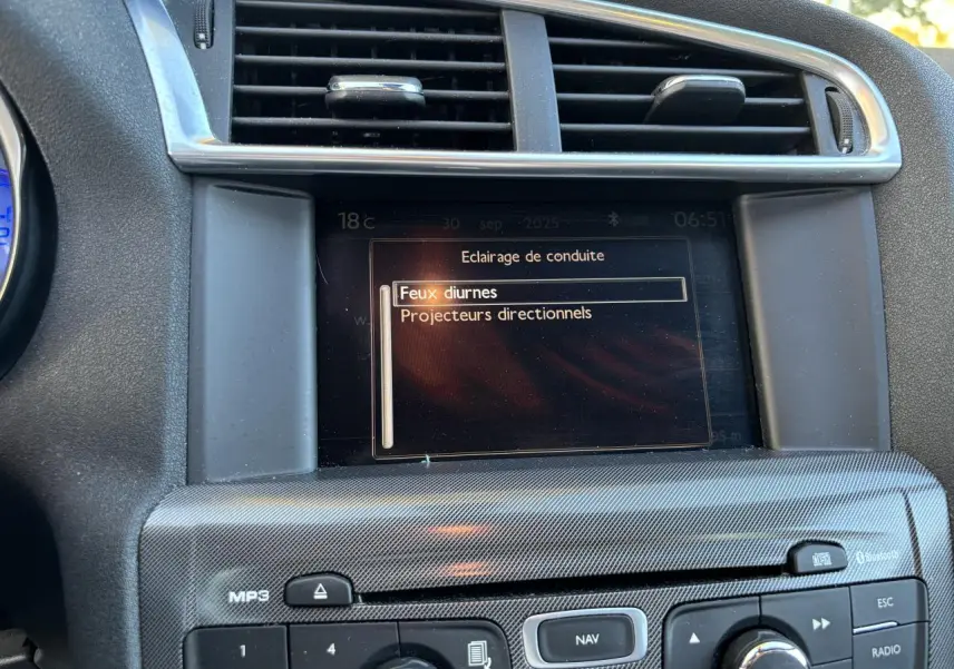 Écran central de la Citroën C4 2012 montrant le menu d'éclairage, entouré de commandes et grilles d'aération.