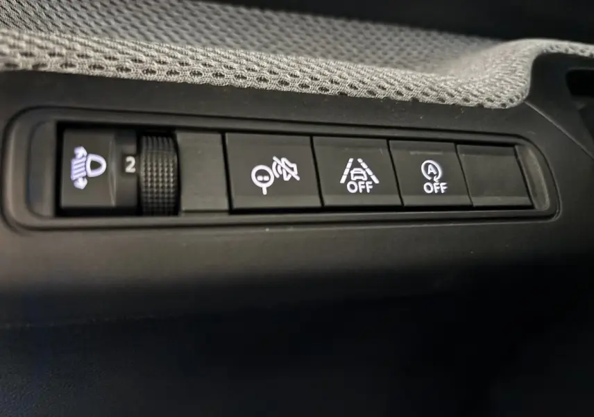 Gros plan sur les boutons de commande noirs du tableau de bord de la Citroën C3 100 BVM PLUS 2025.
