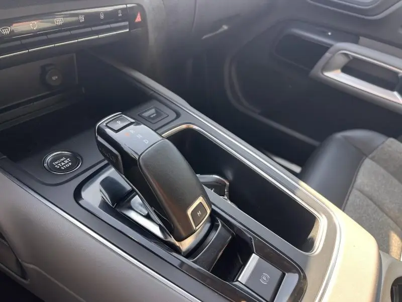 Gros plan sur la console centrale intérieure du Citroën C5 Aircross gris, mettant en valeur le levier de vitesse automatique et le bouton start/stop.