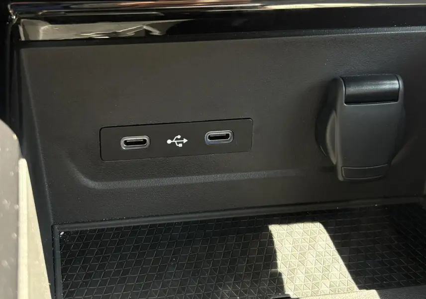Gros plan sur la console centrale du Renault Espace VI hybride, montrant deux ports USB-C et une prise 12V noire.