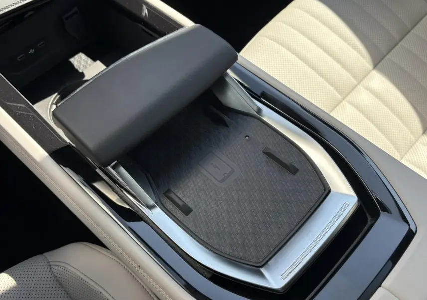 Gros plan sur la console centrale avec chargeur smartphone à induction et accoudoir textile gris sable dans Renault Espace Bleu Nocturne.