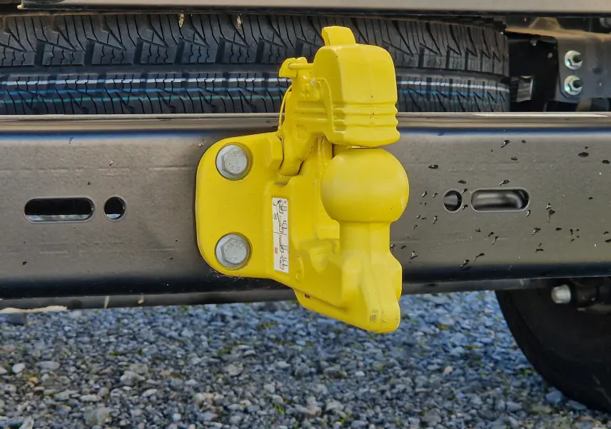Gros plan sur l'attelage jaune fixé au châssis arrière du FIAT Ducato Chassis Benne blanc 2023.